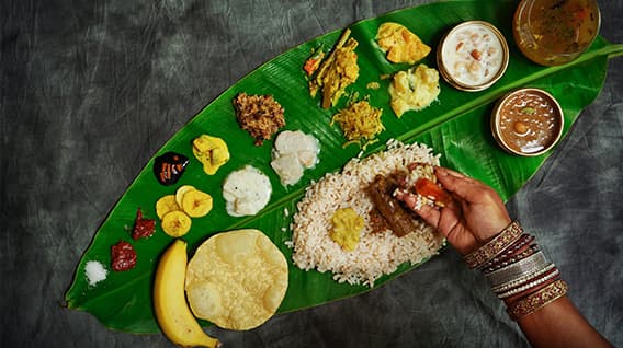 Experience Kerala's flavors with Adithya's Traditional Sadhya, served on a banana leaf.